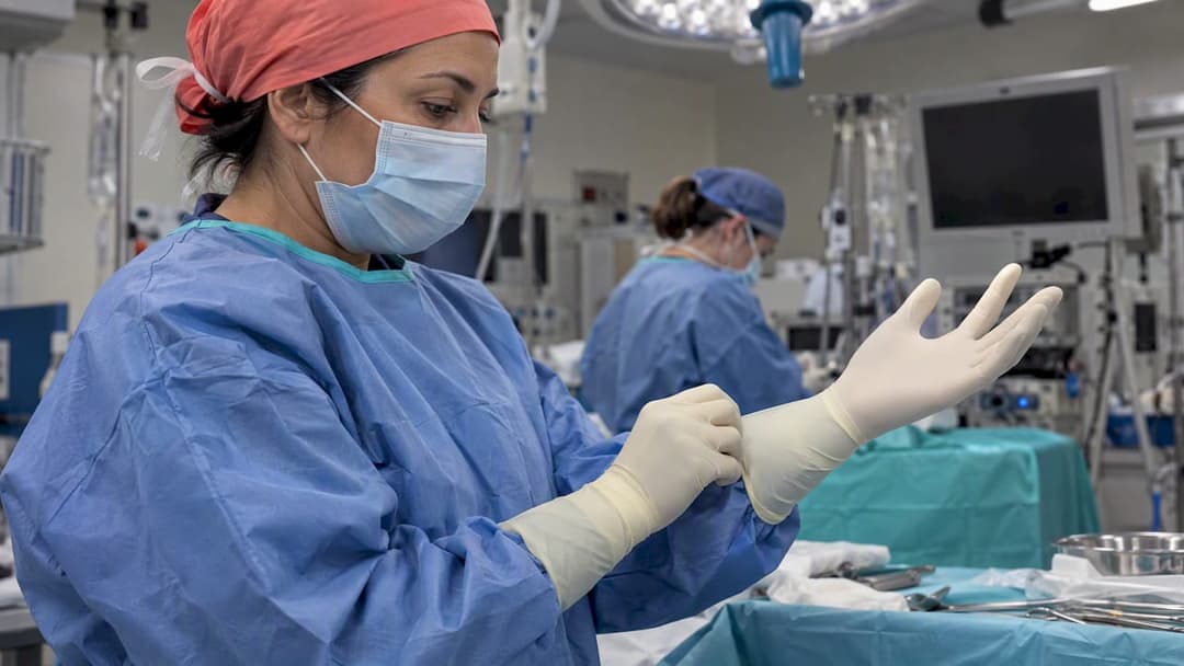 Clinician pulls on a second sterile glove