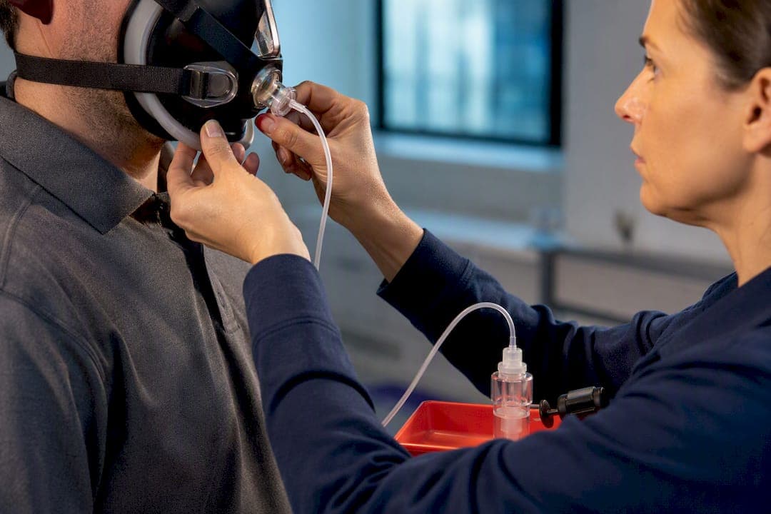 Technician adjusting respirator during fit test