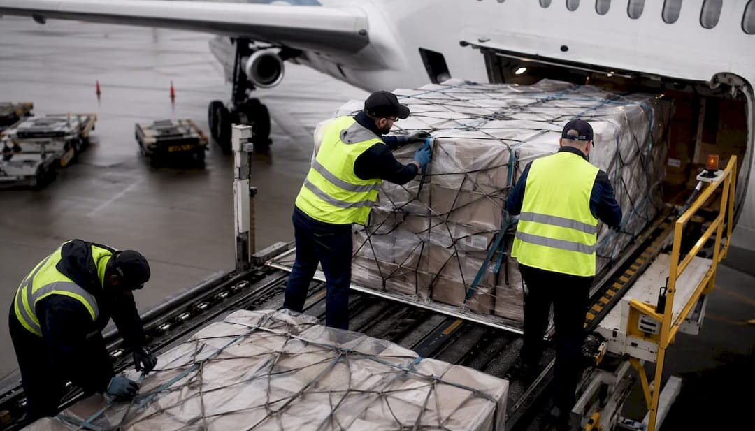 Hands securing medical supply pallets for air freight